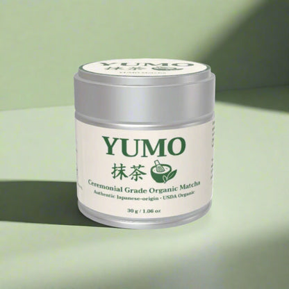 YUMO Ceremonial Grade Organic Matcha container on a green background
